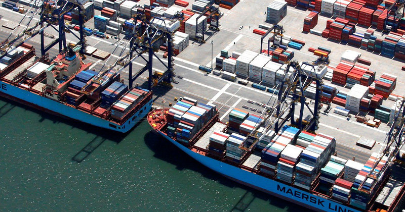 Navios da Maersk atracados no Terminal de Santos durante operações logísticas, destacando a movimentação de contêineres e expansão portuária.